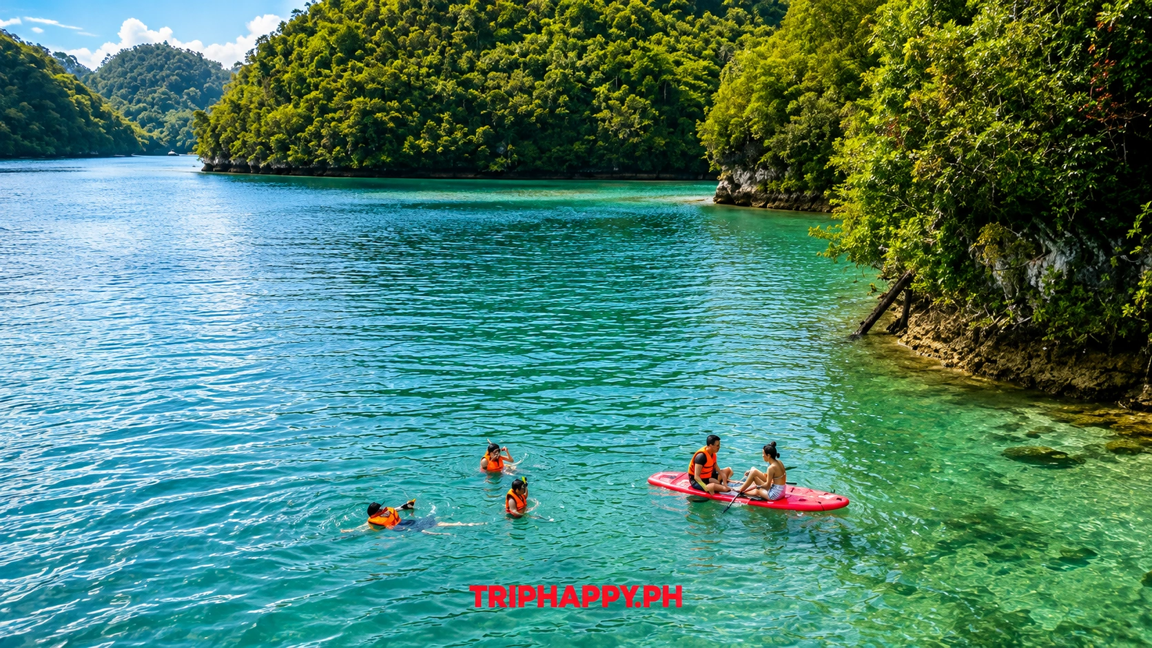 Visitors swimming and kayaking in the clear turquoise waters of Sugba Lagoon surrounded by dense green forest