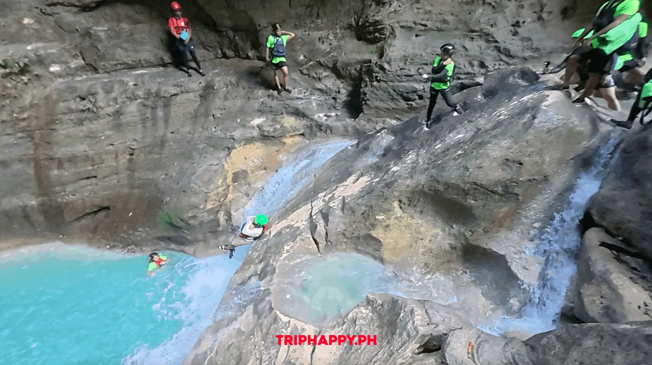 Guest sliding down a natural rock formation during the Kawasan canyoneering tour.